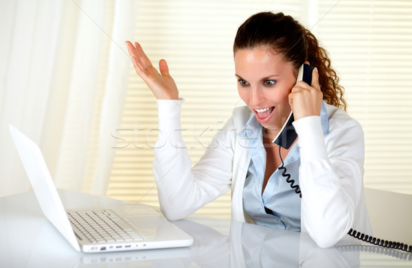 Stock photo: Excited young woman talking on phone