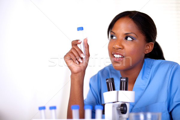 Scientific woman looking right holding test tube Stock photo © pablocalvog