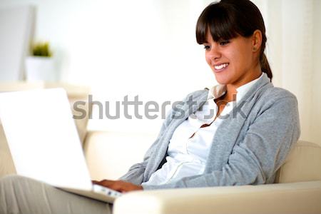 Young woman sitting on couch with tv remote Stock photo © pablocalvog