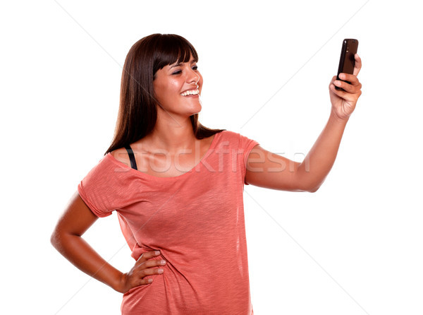 Smiling woman taking a photo with her cellphone Stock photo © pablocalvog