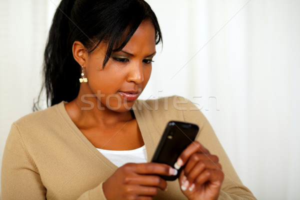 Reflective young woman reading a message on mobile Stock photo © pablocalvog