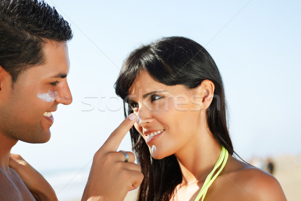 couple on the beach  putting on cream Stock photo © pablocalvog