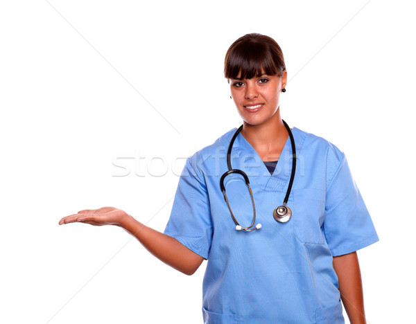Pretty nurse holding out her palm copyspace Stock photo © pablocalvog