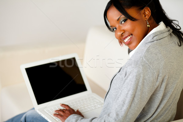 Afro-american female browse the Internet on laptop Stock photo © pablocalvog
