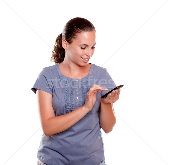 Charming young female sending message by cellphone Stock photo © pablocalvog