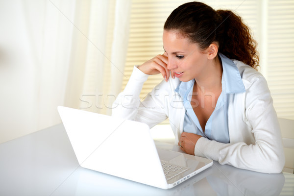 Stock photo: Beautiful young woman reading message on laptop