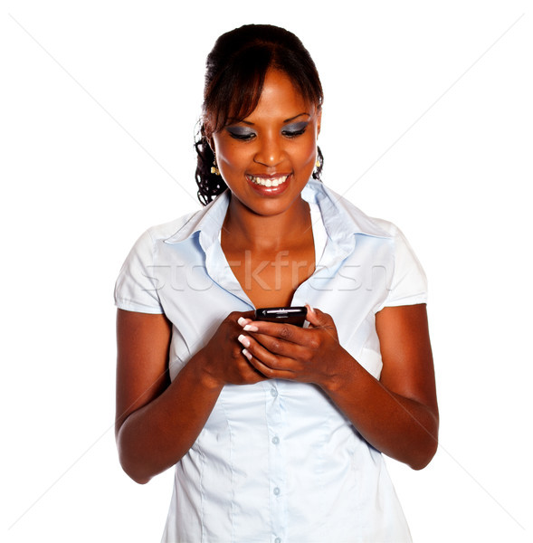 Stock photo: Charming young woman sending message by cellphone