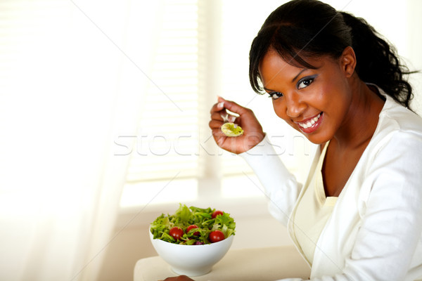 Smiling pretty woman eating green salad Stock photo © pablocalvog