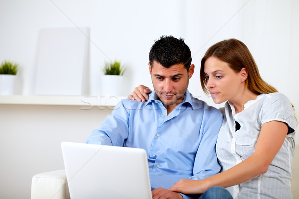 Interested couple browsing on laptop Stock photo © pablocalvog