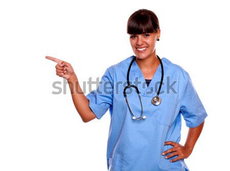 Uśmiechnięty młodych pielęgniarki patrząc wskazując Zdjęcia stock © pablocalvog