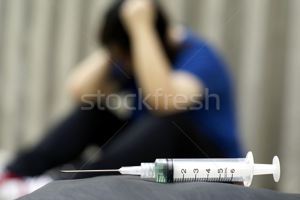 Syringe and female addict in anguish Stock photo © palangsi
