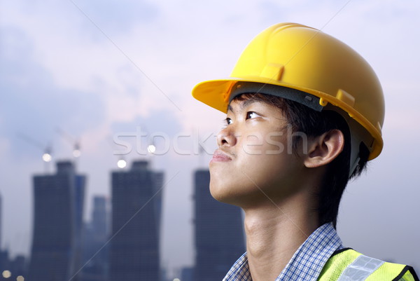 Young asian construction engineer wearing yellow hardhat Stock photo © palangsi