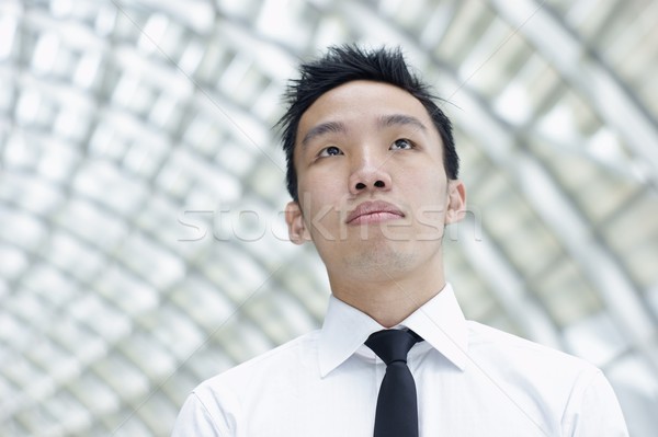 Asian male executive looking up indoors Stock photo © palangsi
