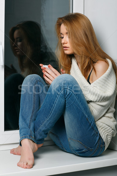 Beautiful long-haired girl, sitting on a window-sill Stock photo © pandorabox