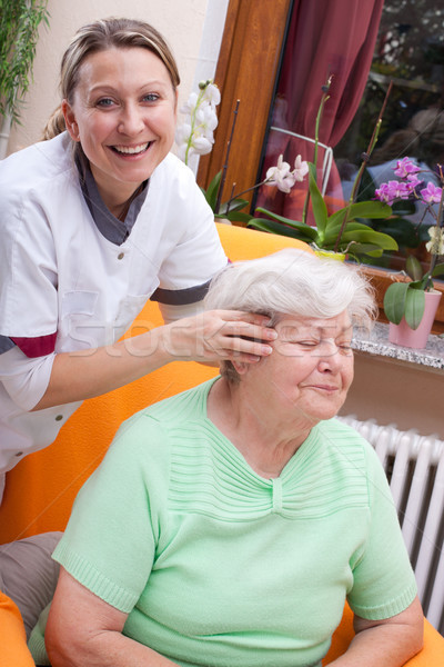 Nurse massages the head of a senior Stock photo © Pasiphae