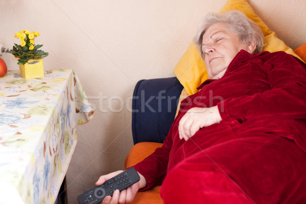 Elderly woman lying on sofa and sleeps Stock photo © Pasiphae