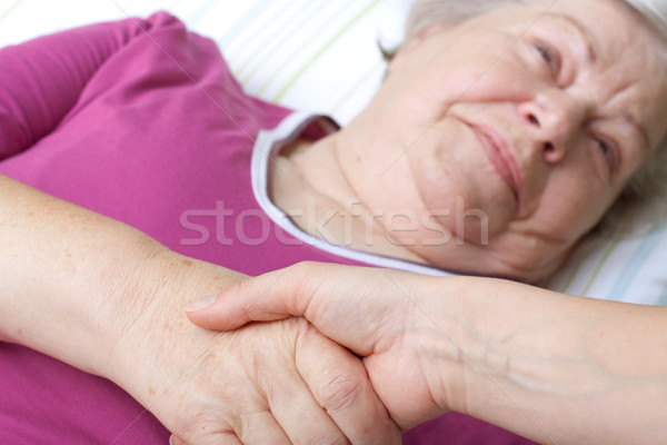 senior lying in bed and welcomes nurse Stock photo © Pasiphae