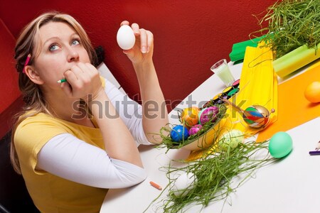 Blonde woman with an easter egg is thinking Stock photo © Pasiphae