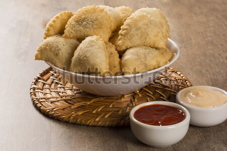 Deep fried stuffed pastry. Brazilian food pasteis. Stock photo © paulovilela