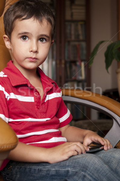 Little boy play smartphone game in leather chair Stock photo © pekour
