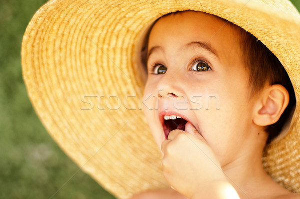 Naughty little boy in straw hat eats raspberry Stock photo © pekour