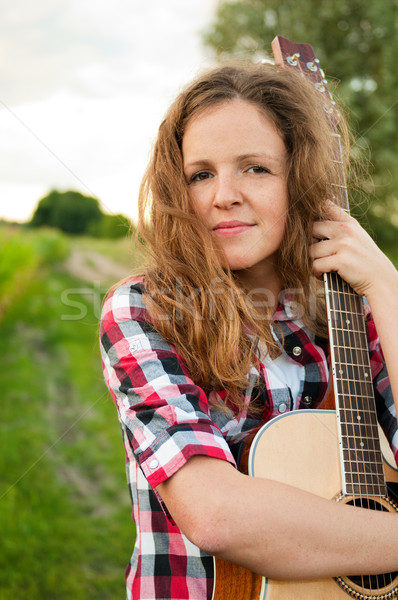 Young redhead woman holding guitar outdoors in summer Stock photo © pekour