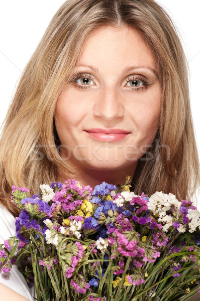 Stock photo: Smiling blonde woman with bouquet of field flowers