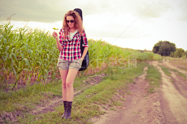 Young redhead woman with guitar passes corn field outdoors in su Stock photo © pekour