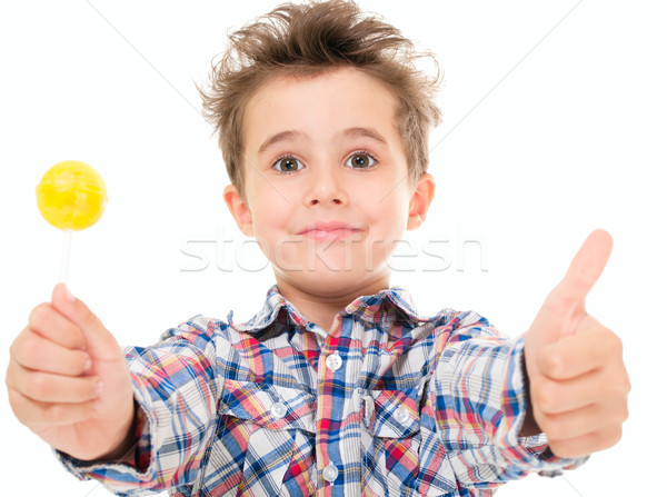 Little smiling boy shows thumb up with lollypop in hand Stock photo © pekour