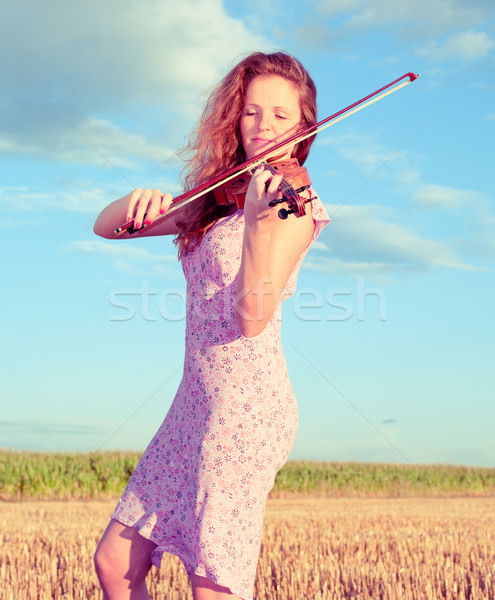Redhead woman playing violin outdoors on the field. Split toning Stock photo © pekour