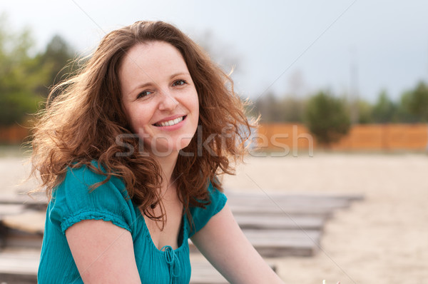 Smiling redhead woman outdoors on the empty beach Stock photo © pekour