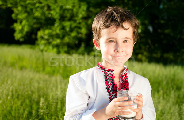 Little ukrainian boy drinks milk outdoors Stock photo © pekour