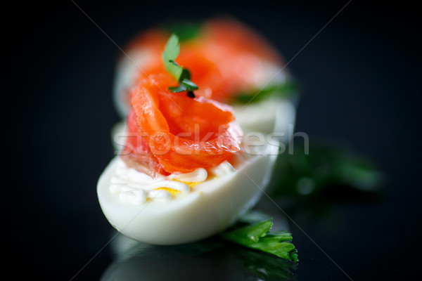 boiled egg with salty salmon on black background Stock photo © Peredniankina
