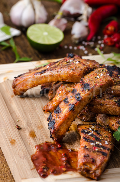 Grilled Spareribs in spicy marinade with beer and rustic bread Stock photo © Peteer
