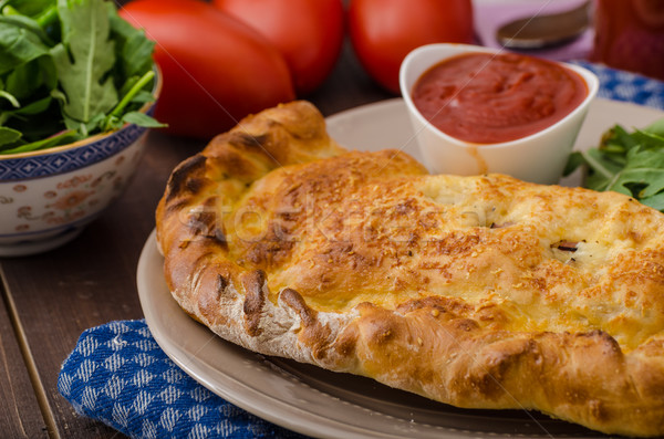 Stock photo: Calzone pizza stuffed with cheese and prosciutto