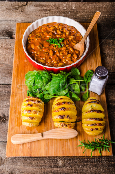 Spicy cowboy beans with hassleback potatoe with herbs Stock photo © Peteer