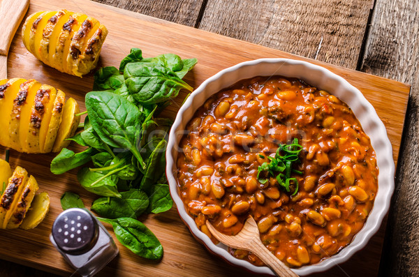 Spicy cowboy beans with hassleback potatoe with herbs Stock photo © Peteer