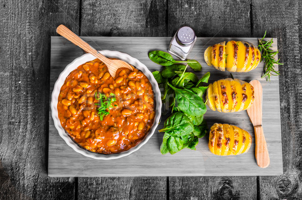 Spicy cowboy beans with hassleback potatoe with herbs Stock photo © Peteer