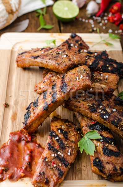 Grilled Spareribs in spicy marinade with beer and rustic bread Stock photo © Peteer