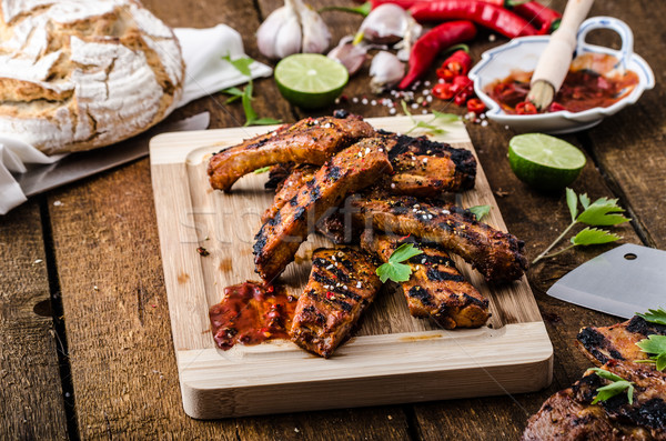 Grilled Spareribs in spicy marinade with beer and rustic bread Stock photo © Peteer