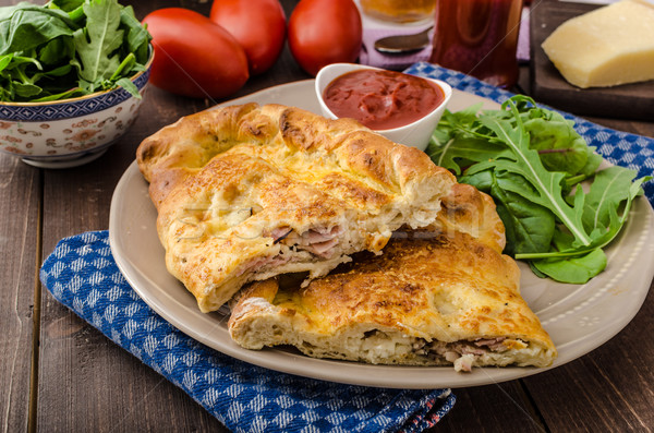 Stock photo: Calzone pizza stuffed with cheese and prosciutto