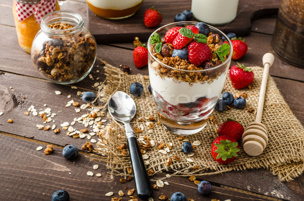 Yogurt with baked granola and berries in small glass Stock photo © Peteer