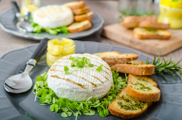 Stock photo: Grilled camembert with herbs, baquettes