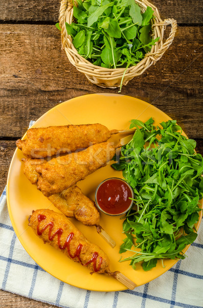 Corn dog with fresh arugula salad and hot dip Stock photo © Peteer