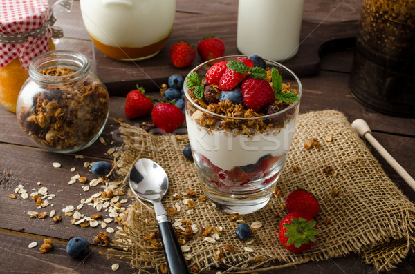 Yogurt with baked granola and berries in small glass Stock photo © Peteer