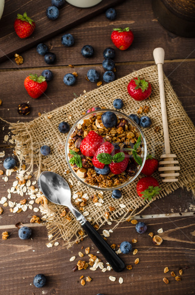 Yogurt with baked granola and berries in small glass Stock photo © Peteer