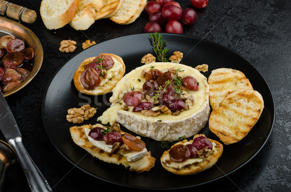 Brie cheese baked with nuts and grapes Stock photo © Peteer