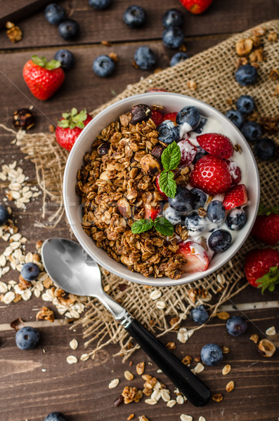 Yogurt with baked granola and berries in small bowl Stock photo © Peteer