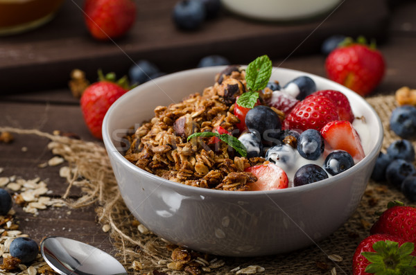 Yogurt with baked granola and berries in small bowl Stock photo © Peteer