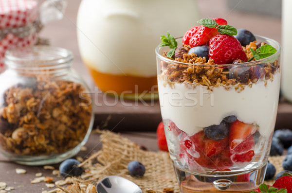 Yogurt with baked granola and berries in small glass Stock photo © Peteer